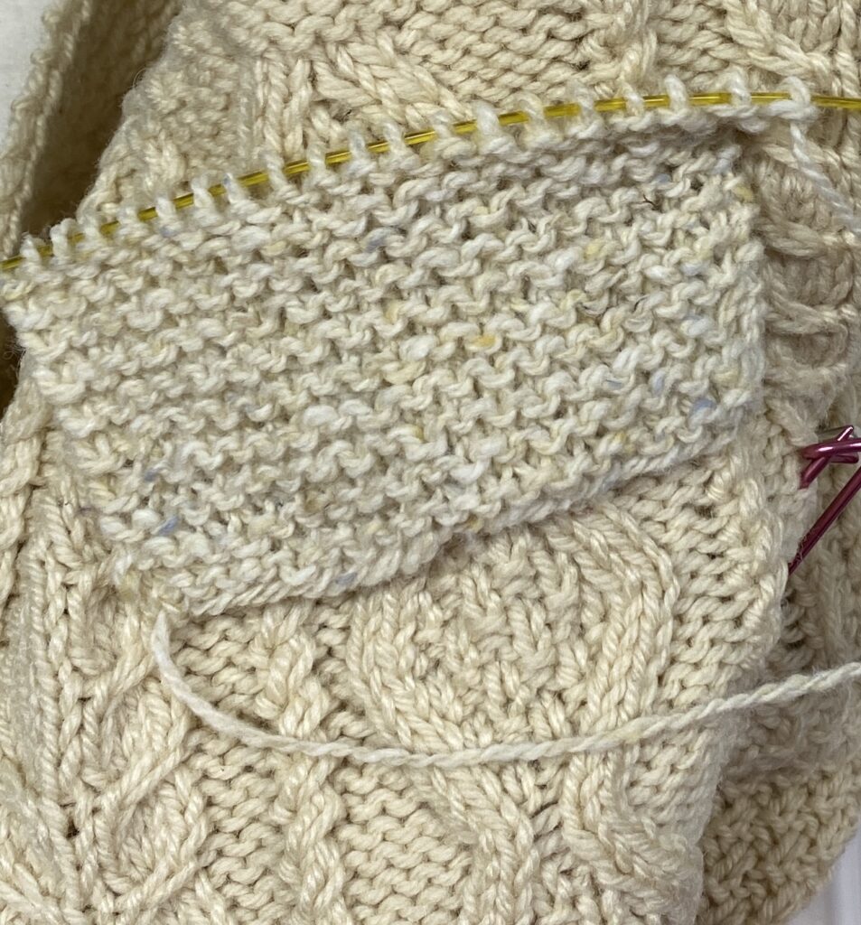 a knitted swatch laying over the sweater