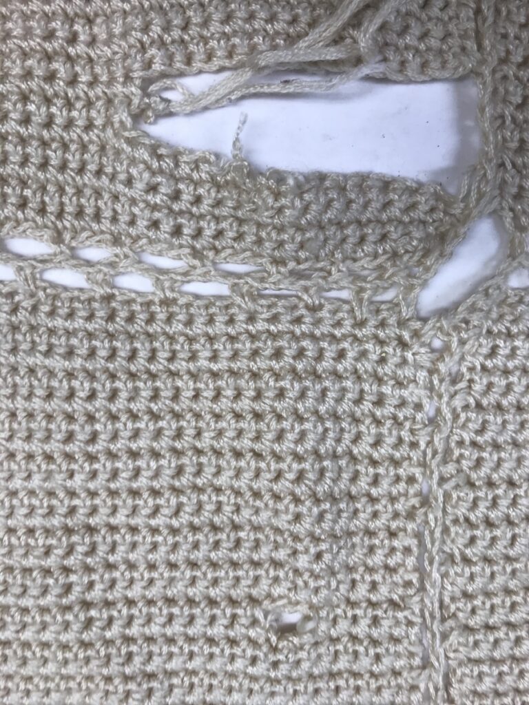 large hole, unraveled section in afghan blanket